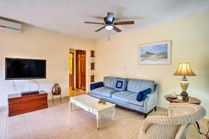 a living room with a blue couch and a flat screen tv at Marina Sol Los Cabos Haven - Walk to Medano Beach! in Cabo San Lucas