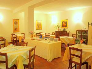 ein Esszimmer mit Tischen und Stühlen mit weißem Tischtuch in der Unterkunft Belvilla by OYO Montecorneo Monolocale in Perugia