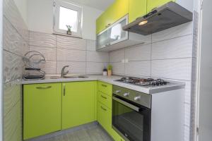 a kitchen with neon green cabinets and a stove at Queen Hvar Luxury Apartment Jacuzzi & Bikes in Hvar
