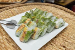 a white plate with some food on a table at Paris Luxury Hotel & Apartment Nha Trang in Nha Trang +140 photos