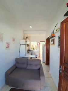 a living room with a couch and a kitchen at Apartamento próximo ao Aeroporto de Florianópolis. in Florianópolis