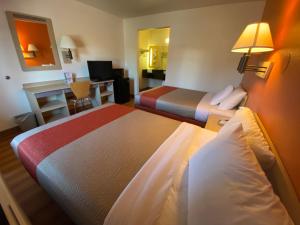 a hotel room with two beds and a desk at Motel 6-Flagstaff, AZ - West - Woodland Village in Flagstaff