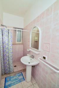 a pink bathroom with a sink and a mirror at SoleMarePonza Casa Maria in Ponza