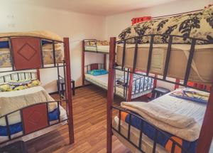 a room with three bunk beds in a room at Goiien House in Torres del Paine