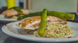 a plate of food with a piece of meat and asparagus at Goiien House in Torres del Paine