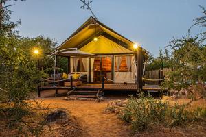 a luxury tent with a bed in a field at Mountain View Safari Lodge in Hoedspruit