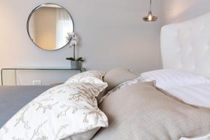 a bedroom with a bed with a mirror and pillows at Shell Luxury Residences with Pool and Whirlpool in Zadar