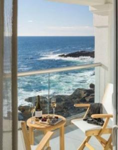 a balcony with a table and two glasses of wine at Cliff House Maine in Cape Neddick