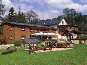 um grande edifício com um parque infantil em frente em Gasthof & Pension Brettmühle em Königswalde