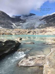un cuerpo de agua en una montaña rocosa con un glaciar en Hotel la Turra, en Termignon
