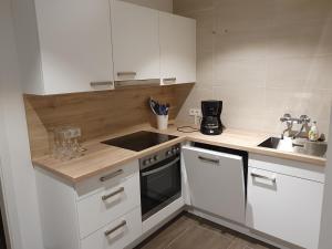 a small kitchen with white cabinets and a sink at Haus am Prekkesee in Xanten