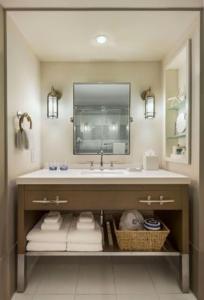 ein Badezimmer mit einem Waschbecken, einem Spiegel und Handtüchern in der Unterkunft Cliff House Maine in Cape Neddick