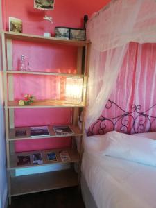 een slaapkamer met een bed en een roze muur bij La Chambre d'hôte de Chris in Cherbourg en Cotentin