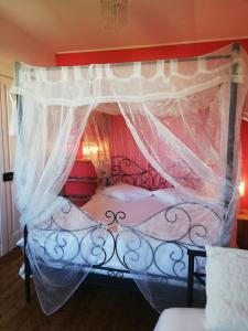 a bedroom with a bed with a canopy at La Chambre d'hôte de Chris in Cherbourg en Cotentin