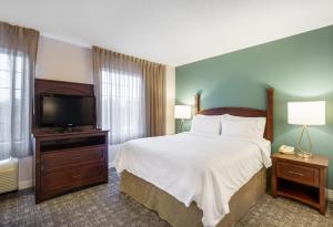 a hotel room with a bed and a flat screen tv at Staybridge Suites Chesapeake-Virginia Beach, an IHG Hotel in Chesapeake