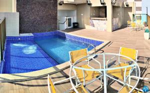 a swimming pool with two chairs and a basketball hoop at Vacanze - Gales de Pajuçara in Maceió
