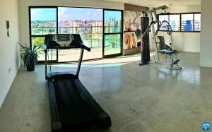 a gym with a treadmill and a view of a city at Vacanze - Gales de Pajuçara in Maceió