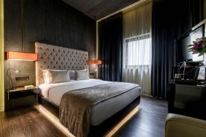 um quarto com uma cama grande e uma janela grande em 9Hotel Mercy em Lisboa