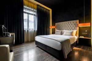 a bedroom with a large bed and a large window at 9Hotel Mercy in Lisbon