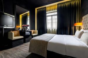 um quarto de hotel com uma cama e uma televisão em 9Hotel Mercy em Lisboa