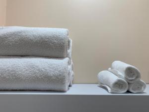 una pila di asciugamani e due rotoli di carta igienica di The Cabot Lodge a Beverly