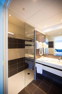 a bathroom with a sink and a glass shower at Hôtel Restaurant Bel Air Crevin - Axe Rennes Nantes in Crévin