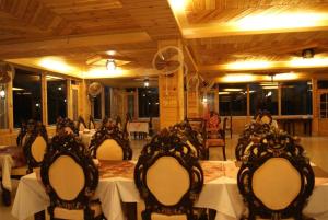 a dining room with tables and chairs in a restaurant at Fairy Land Hotel in Hunza Valley