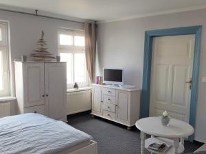 a bedroom with a bed and a tv and a table at Ferienwohnung Sassnitz mit Meerblick in Sassnitz