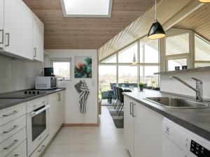 une cuisine avec des placards blancs et une grande fenêtre dans l'établissement 8 person holiday home in Idestrup, à Bøtø By