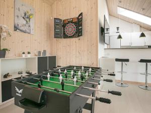 a room with a table with a dartboard on the wall at 8 person holiday home in Idestrup in Marielyst