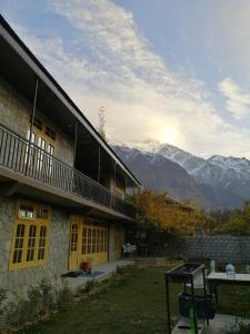 a building with a balcony and mountains in the background at Baigs Paradise Guest House in Alīābād