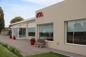 a building with a bench outside of it at Motel A.C.A. Cipolletti in Cipolletti