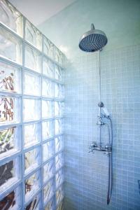 a shower in a bathroom with blue tiles at Casa Santolina in Cala Saona