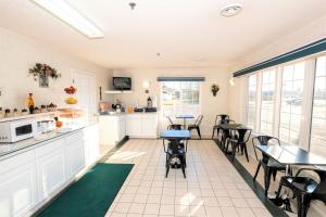 a kitchen and dining room with tables and chairs at Mountain Host Motor Inn in Iron Mountain