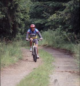 un hombre montando una bicicleta por un camino de tierra en Haus Hinzberg, en Oberhof