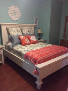 a bedroom with a bed with red pillows on it at Ababor Suites Guesthouse in Vieques