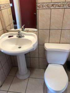 ein Badezimmer mit einem weißen Waschbecken und einem WC in der Unterkunft Aqua Inn Motel in El Monte