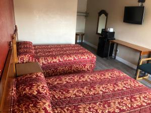 um quarto de hotel com duas camas e um espelho em Aqua Inn Motel em El Monte