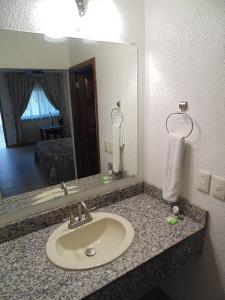 a bathroom counter with a sink and a mirror at Hotel Hacienda in Ciudad Guzmán