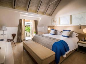 a large bedroom with a large bed with blue pillows at Sofitel Legend Santa Clara Cartagena in Cartagena de Indias