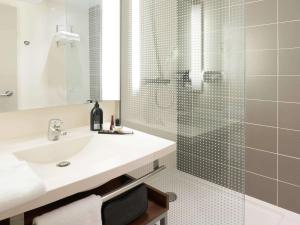 图卢兹Aparthotel Adagio Toulouse Centre Ramblas的带水槽和淋浴的浴室