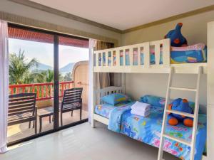 Schlafzimmer mit Etagenbetten und Balkon in der Unterkunft Novotel Phuket Resort in Patong Beach