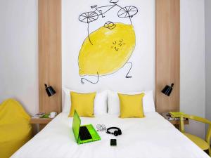 a bed with a laptop and a drawing of a lemon at Ibis Styles Budapest City in Budapest