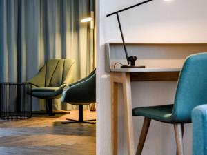 a room with a desk and chairs and a lamp at Novotel Zurich City West in Zürich