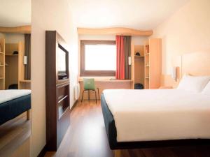 een hotelkamer met een bed, een bureau en een raam bij ibis Grenoble Gare in Grenoble