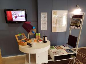 Cette chambre dispose d'une table et d'une télévision murale. dans l'établissement ibis Styles Arles Palais des Congrès, à Arles