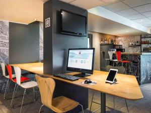 ein Büro mit einem Schreibtisch mit einem Computer und Stühlen in der Unterkunft ibis Paris Saint-Denis Stade Sud in Saint-Denis + 31 Fotos