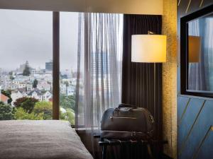 a hotel room with a bed and a large window at Mövenpick Hotel Wellington in Wellington
