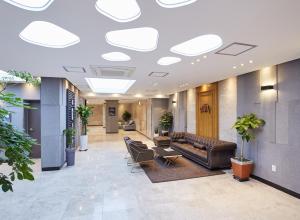 a lobby with couches and chairs in a building at Noble Stay Hotel in Gwangju