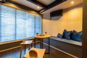 een kamer met een tafel en een raam met blauwe kussens bij TABITABI STAY KAWAMA in Kyoto